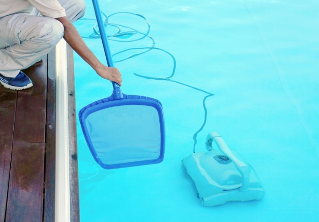 A Person Cleaning a Pool With a Pool Cleaner