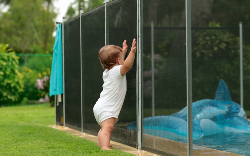 baby leaning swimming pool fence protection infant standing safety gate