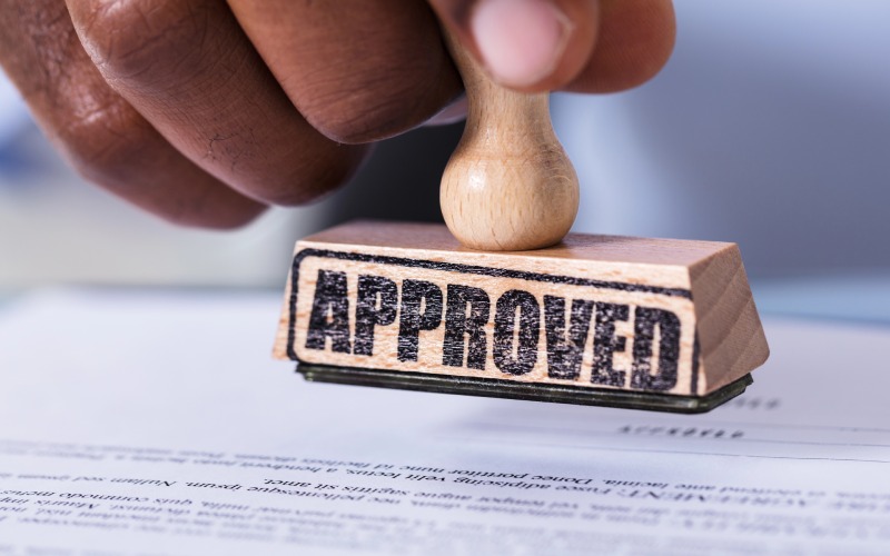 close-hand-holding-wooden stamp defocused document